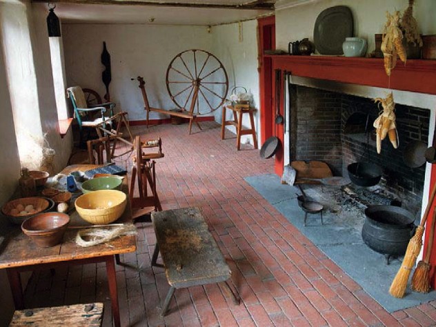 Open hearth, spinning wheel, and other elements in the colonial-era Sylvanus Brown House in Pawtucket, Rhode Island
