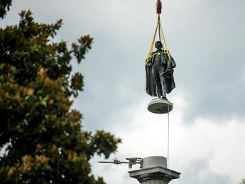 Photograph of John C. Calhoun statue in Charleston in midair being lifted up by a crane