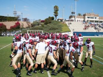 <strong>On the road:</strong> Crimson team members huddled before taking the field at Torero Stadium for Harvard’s first West Coast game since 1949. The University of San Diego’s small but picturesque facility has a seating capacity of 6,000. 