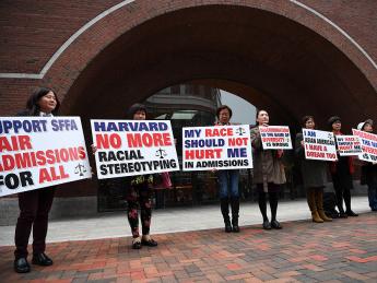 hotograph of demonstrators in front of the federal courthouse in Boston where the SFFA v. Harvard trial took place, with signs reading "Harvard No More Racial Stereotyping" and "My Race Should Not Hurt Me In Admissions.
