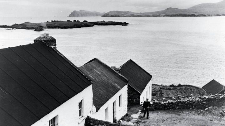 Blasket Island home: The National School (left, upper image) and the Carneys&rsquo; home (middle structure), with father Se&aacute;n Tom &Oacute; Ce&aacute;rna outside.