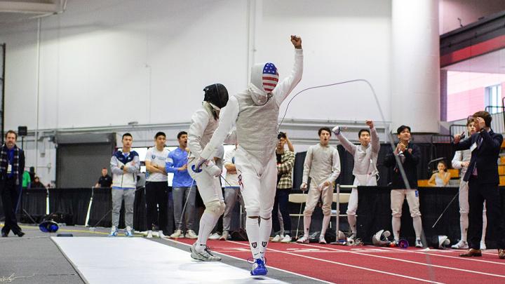 A fencer walks away from his opponent, holding up a fist