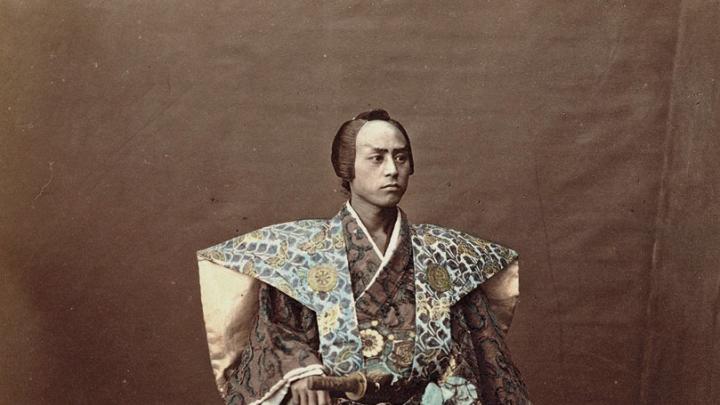 1870s Japan: a hand-tinted albumen print by Raimund von Stillfried showing a man costumed as a samurai warrior